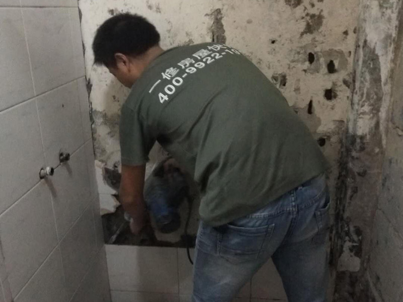 局部瓷磚拆除裝修：衛(wèi)浴用具拆除后可以對墻面瓷磚進(jìn)行拆卸。拆卸一般是從墻體的下方往上方敲，從瓷磚的邊緣往里面敲，還需要根據(jù)拆卸的位置選擇適當(dāng)?shù)那么u力度。敲磚是從墻體下方開始敲，從每塊瓷磚的邊緣開始敲。如果先敲上面的瓷磚，地面堆積瓷磚較多，擋住墻體下面的瓷磚，不利于拆卸。另外，敲磚過程中，要不是對地面的瓷磚進(jìn)行清理，以免瓷磚過多堆積，減慢施工進(jìn)度以及造成施工意外。 由于二手房的衛(wèi)浴在之前是做了一次防水的，因此在敲磚時必須注意防水層的處理，與屋主溝通好，防水層是否打掉。舊的防水層一般都不打掉，在敲磚后，在原有的防水層上面，再薄薄做一層防水，以提高衛(wèi)浴的防水能力。但如果屋主需要把防水敲掉重新再做。則敲磚需要打到批土層或打到見底。敲插座和龍頭附近的瓷磚時，要慢慢敲，小心摸清電線和水管的走向，以防損壞電線和水管。如果電線或水管已經(jīng)損壞了，要及時進(jìn)行修補處理，以免留下更多后續(xù)工程。