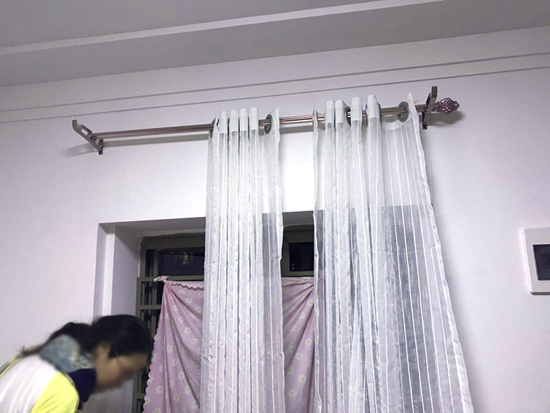 窗簾桿安裝：首先羅馬窗簾桿長度超過2.5米，需要三個(gè)安裝碼。其次中間的安裝碼為于窗戶或墻壁中心，兩端安裝碼需等距離窗戶邊緣至少5-10cm，窗簾桿需離窗戶頂端15-20cm。然后打孔深度為3.5-5cm，不能跑眼，歪斜。接著安裝碼用自攻螺絲堅(jiān)固，吊環(huán)套入桿內(nèi)，吊環(huán)一分為二，兩端各留一個(gè)吊環(huán)，將羅馬窗簾桿壓入開口安裝碼內(nèi)。之后進(jìn)行調(diào)整，使兩端裝飾頭離開墻壁距離一致。最后將窗簾穿好掛鉤，把掛鉤的另一端掛入吊環(huán)的孔內(nèi)，左右開合窗簾，檢查滑動是否靈活、兩副窗簾是否等高，否則需進(jìn)行微調(diào)。