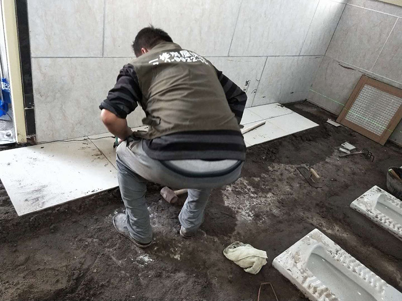 公廁貼磚維修：基層處理：應(yīng)全部清理墻面上的各類污物，打掃干凈現(xiàn)場，特別是腳落里。 批墻、墻面找平：用泥刀先批墻，后用水泥漿找平。這個工序很重要，確保底子平，防止貼后空鼓。 刷防水涂料：墻面要刷防水涂料，防止貼后浸水，一般高度不低于1.8米，刷的時候會稍高一些。 找水平基準線：根據(jù)設(shè)計鋪貼圖樣的要求，確定排磚方案，用墨斗彈線，以減少施工損耗。 粘結(jié)劑上墻：把剛剛攪拌好的粘結(jié)劑漿料均勻的刮到墻上。 瓷磚上墻將經(jīng)過預(yù)先清潔的瓷磚平整地鋪貼在粘結(jié)劑漿料基層上，使用橡膠錘將瓷磚拍實鋪平。施工過程中，可小幅度轉(zhuǎn)動瓷磚，使?jié){料與瓷磚背面充分接觸。專家建議在鋪貼時，隨機取下已鋪貼于基層上的瓷磚作檢查。確保漿料與瓷磚背面的充分接觸。 留縫大小調(diào)整根據(jù)瓷磚的尺寸，在磚與磚之間預(yù)留相應(yīng)尺寸的縫隙留待嵌縫。可用牙簽等先固定，粘結(jié)劑具有一定的可調(diào)整性，可對留縫的大小進行調(diào)整。