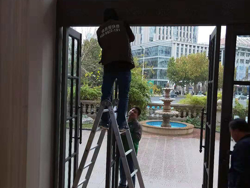 室外門維修：首先安裝門框，這個門檻是事先量好尺寸制作好的。把門框靠在門洞里，一般是安裝門扇的那邊靠墻。并使用沖擊鉆鉆孔，安裝2只膨脹螺絲。然后打安裝孔，使用膨脹螺絲穿過門框，在門框的后面適當?shù)募尤?個斜頭木楔，并使用卷尺量好同樣的寬度，通過調(diào)節(jié)斜頭木楔的長短達到合適的寬度。緊固好2只膨脹螺絲后就可以把門扇放入門框里，查看尺寸是否合適。并安裝門框上的合頁。把合頁對好位置，并使用鉚釘槍打入鉚釘，固定合頁，然后再在合頁上打第二個孔和安裝鉚釘。同樣的步驟安裝好門框下的合頁。完成2只合頁的安裝后就把門扇放入門框里，以合頁的安裝位置為基礎(chǔ)，移動門扇，達到最佳安裝位置。如果門扇短一些，就可以在門扇底部墊斜頭進行支墊。位置合適后使用記號筆做好合頁螺絲安裝孔位置。再使用手槍鉆鉆孔和使用鉚釘槍加入鉚釘。打開門查看移動是否靈活，再完成剩下的孔的鉚釘安裝。