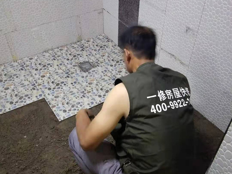 衛(wèi)生間地面花磚鋪貼:找平，就是在鋪仿古磚前，對(duì)鋪貼物表面進(jìn)行處理，如地面、內(nèi)墻面、外墻面等，消除表面附著的污物，并灑水進(jìn)行滋潤，然后用水泥沙混合找平，通常使用灰鏟在表面不停的涂抹使水泥地面保持大致水平，一定要等到水泥沙混合物完全干爽后再行鋪貼。用一段較長的細(xì)線，根據(jù)確定的鋪貼方式，在線上涂上顏色或白灰，然后在找平的地面上畫出仿古磚的位置及磚縫的參考線。 將亞光磚置入清水中浸泡，使瓷磚充分吸收水分，以不冒出氣泡為準(zhǔn)，防止干燥瓷磚在裝修完成后再次吸水而導(dǎo)致磚體變形。取出浸泡好的瓷磚，抹干水漬，在找平層上噴灑足夠的水，然后在磚背面均勻抹上水泥沙漿，沙漿厚度5~6cm為宜，鋪貼大規(guī)格亞光磚時(shí)適當(dāng)加厚；隨即將磚貼上，用木錘輕輕拍牢平整，避免空鼓，并隨時(shí)用直尺找平。