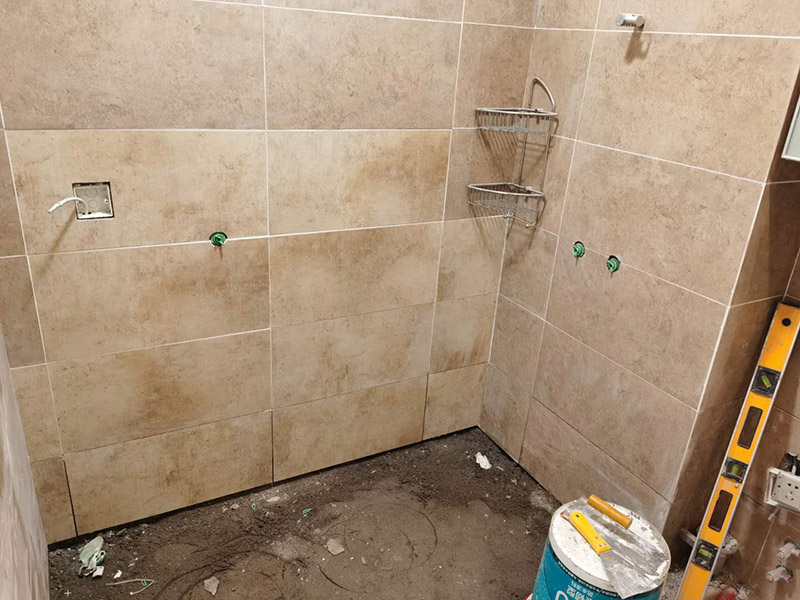 衛(wèi)生間瓷磚鋪貼：基層處理--抹底子灰--彈線排磚--侵磚--鑲貼--擦縫--交工驗(yàn)收 首先進(jìn)行地面清掃，不打掃干凈會(huì)翹邊、空鼓的;放水平du線然后分塊;地面要濕潤(rùn)進(jìn)行灑水;采用兩種砂漿，打砂漿的基層，一般要進(jìn)行干鋪;地磚是不是出現(xiàn)了空鼓是很重要的;還要在磚底涂抹上漿;鋪貼的時(shí)候要用橡皮錘敲擊，做拉縫、表面清理，對(duì)瓷磚進(jìn)行勾縫處理即可。最重要的是保護(hù)好成品，以防造成污染和損傷。