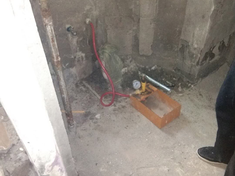 衛(wèi)生間管道打壓安裝：其使用方法是把冷熱水管用軟管連接在一起這個冷熱水形成一個圈，成一根管了，試壓器接在任何一個出水口都可以這時的壓力指針是0個壓。當所有水管通路全部焊接好后才可以試壓，在測壓前要封堵所有的堵頭，關閉進水總管的閥門。測壓時，搖動千斤頂?shù)膲簵U直到壓力表的指針指向0.9-1.0左右，也就是說現(xiàn)在的壓力是正常水壓的3倍保持這個壓力值一定時間。不同的水管測壓時間不一樣，PPR、鋁塑PPR、鋼塑PPR等焊接管是30分鐘（只能超出不能少）。鋁塑管就是銅接頭的那種，它的時間是4個小時（半個工作日）。鍍鋅管是4個小時也是半個工作日。