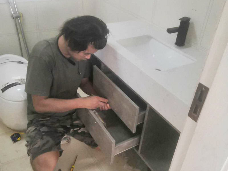 浴室柜及燈具安裝：安裝前，檢查零配件是否齊全。安裝三角閥，確保冷熱進水管保持齊平。測量距離，安裝下水管。涂抹膠水要均勻，確保管與管間連接緊密。安裝柜角，看所有角是否在同一水平。裝好后可做適當?shù)恼{整。將浴室柜靠墻放好?？催M出水管位置是否得當，不合適時需做一定改動。安裝臺盆的龍頭。龍頭最好與浴室柜配套購買，這樣出水角度較為適合。用螺母固定臺盆龍頭。固定時一只手要扶好龍頭，以免裝好后位置偏離。將裝好龍頭的臺盆放在浴室柜上，調整位置到最佳為止。連接臺盆的進出水管及下水，長度適當，位置合理。裝好柜體的把手，并進行適
