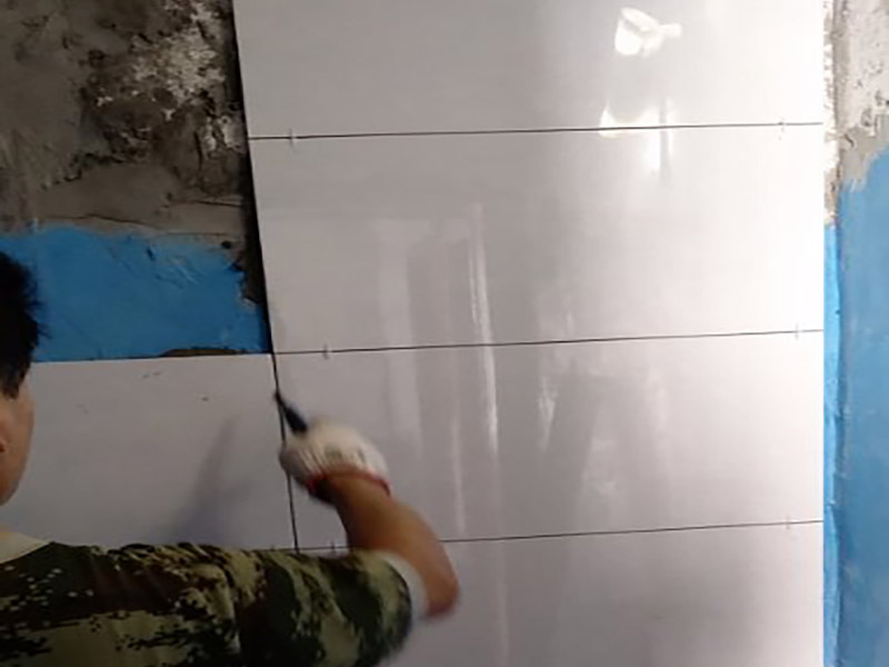 墻面瓷磚鋪貼施工：（1）基層處理：將塵土、雜物徹底清掃干凈，不得有空鼓、開(kāi)裂及起砂等缺陷。 （2）彈線(xiàn)：施工前在墻體四周彈出標(biāo)高控制線(xiàn)，在地面彈出十字線(xiàn)，以控制地磚分隔尺寸。 （3）鋪貼：鋪設(shè)選用1：3干硬性水泥砂漿，砂漿厚度25mm左右。鋪貼前將地磚背面濕潤(rùn)，需正面干燥為宜。把地磚按照要求放在水泥砂漿上，用橡皮錘輕敲地磚飾面直至密實(shí)平整達(dá)到要求。 （4）勾縫：地磚鋪完后24h進(jìn)行清理勾縫，勾縫前應(yīng)先將地磚縫隙內(nèi)雜質(zhì)擦凈，用專(zhuān)用填縫劑勾縫。 （5）清理：施工過(guò)程中隨干隨清，完工后(一般宜在24h之后)再用棉紗等物對(duì)地磚表面進(jìn)行清理