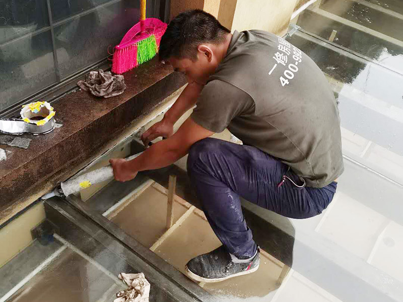 屋頂防水打膠案例：不少建筑新建成就滲漏，老建筑的滲漏現(xiàn)象更嚴重。第一步：把玻璃的邊清理干凈。把玻璃固定到位。在玻璃邊緣3mm處貼美文紙。第二步：用結構膠往縫里填到60％。第三步：用和縫大小的泡抹棒往里壓填充，把膠往玻璃與型材的縫里擠。第四步：填充耐候密封膠，用刮刀來回30度角度刮2遍。缺膠的補上。30分內(nèi)把紙揭掉。