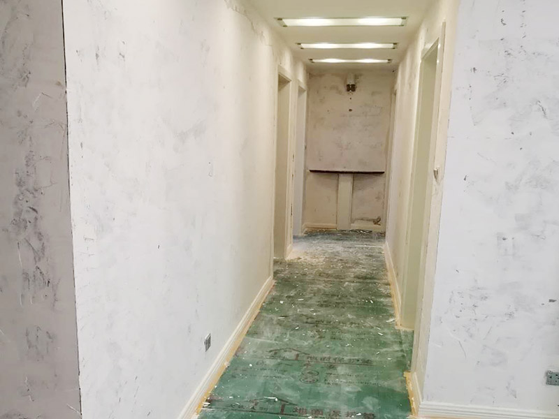 全屋墻面鏟除翻新：首先用水將墻面浸濕，這樣在鏟除墻面時(shí)比較省力，墻面必須要鏟到露出水泥砂漿面。然后是涂刷界面劑，一定要全部都刷到而且要均勻。墻面的裂縫通常都是用牛皮紙帶及白乳膠來貼住，但不能保證它能百分百不再開裂。 2、 如果墻面凹凸不平，那么就需要用石膏來找平，誤差最好不要超過0.5公分。非承重墻一般都是需要貼布的，所以最好選擇質(zhì)地好的墻布和白乳膠，有條件的話可以使用網(wǎng)格布，對于防裂效果會(huì)更好。 3、 在挑選膩?zhàn)訒r(shí)應(yīng)該選顆粒細(xì)度高及質(zhì)地較硬的，或是把白乳膠添加到膩?zhàn)又刑岣吣佔(zhàn)拥挠捕?。打磨墻面要選用細(xì)砂紙，砂紙如果過粗會(huì)在墻面上留下很深的砂痕，就算是刷漆也沒辦法遮蓋住。墻面打磨之后要清掃一遍，否則粉塵過多會(huì)影響到漆的附著力。 4、 墻面在刷底漆時(shí)，一定要把每個(gè)地方都刷到并且要均勻。刷底漆要使用質(zhì)地好滾筒，以免影響到底漆涂刷的效果。在膩?zhàn)哟蚰ブ?，墻面都?huì)留下一些比較難看的坑眼，特別是在刷漆后非常明顯，所以需要找補(bǔ)。在找補(bǔ)時(shí)一定要打磨平整，為了避免出現(xiàn)色差坑眼在底漆里多加一點(diǎn)水再涂刷。