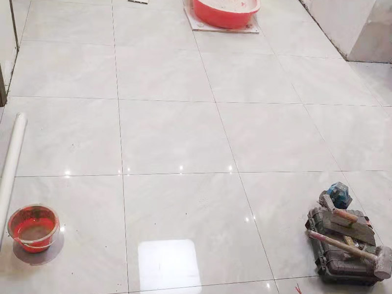 客廳地磚鋪貼:鋪貼前應(yīng)用水泥砂漿找地面或墻面，并按磚體尺寸劃好線，劃線時(shí)需預(yù)留3－5mm的灰縫，以防粘結(jié)物與磚體膨脹系數(shù)不一致而導(dǎo)致不良后果產(chǎn)生。 瓷磚受熱或者冬天遇冷會(huì)存在一定熱脹冷縮，同時(shí)粘貼瓷磚的水泥沙土也會(huì)隨著溫度和濕度的變化出現(xiàn)一定膨脹收縮，瓷磚間不留縫隙很容易導(dǎo)致瓷磚起拱裂開。瓷磚邊緣存在一定誤差，每塊瓷磚不能保證完全的平整，特別是裝修現(xiàn)場(chǎng)切割瓷磚容易出現(xiàn)誤差，留縫能保持整體整齊劃一。 