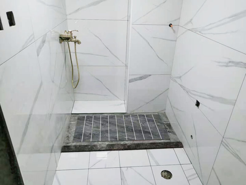 浴室貼磚裝修翻新：在鋪貼瓷磚前，我們要先把還沒涂抹水泥的地磚鋪在地上，并敲平，然后在地磚上涂滿水泥，鋪在地面，鋪地磚的過程中要對齊四塊磚的對角位置。   另外，在鋪貼瓷磚時也要講究鋪貼順序，在鋪地磚時應從內(nèi)向外貼，有坡度或地漏的地方，要注意排水方向找坡，而墻面磚應從下往上貼，底層的瓷磚要最后貼，這樣鋪貼出來才美觀，我們鋪完地磚后還要壓地磚。