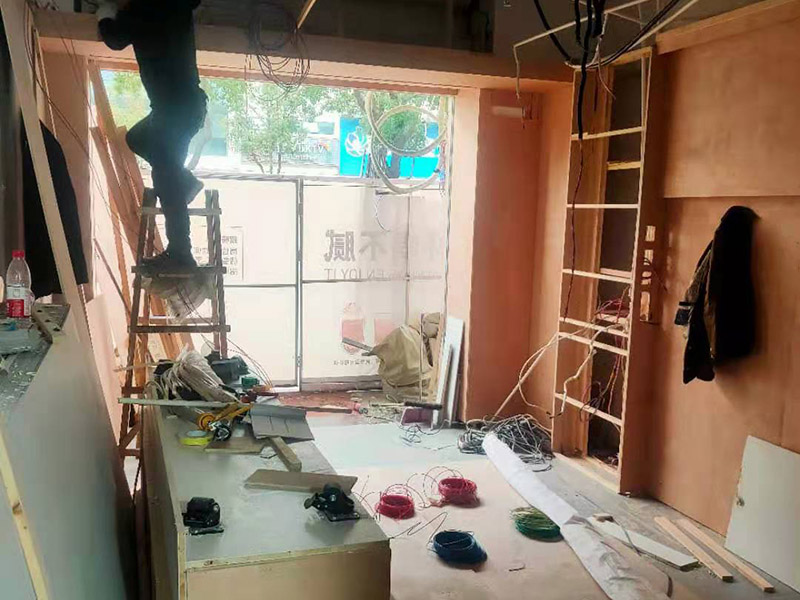 門店木工施工現(xiàn)場:首先應(yīng)該搭建木作施工臺。木作施工臺用于板材的切割板，板材的造型，板材的平整度處理等等。門窗的制作包括門窗套制作、門窗制作。要特別注意門窗扇與框之間的縫隙不能太大，以及門窗套與門窗的色差等。木作表層封裝木制品制作完成后，對其表面進行細節(jié)封裝。木作表層封裝通常就要用到各種各樣的家裝板材，特別注意板材的選購。