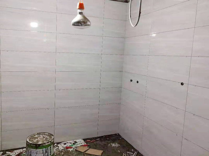浴室貼磚裝修:把還沒有涂抹水泥的地磚鋪在地上，把它們敲平，然后在地磚上涂滿水泥，鋪在地面，保持四塊磚的對角位置對齊。 鋪瓷磚的順序其實(shí)也是有不少講究的，鋪地磚的時(shí)候應(yīng)該從內(nèi)向外貼，遇到坡度或者有地漏的地方，還要注意排水方向找坡；墻面磚的鋪貼應(yīng)該從下向上進(jìn)行。為了最后的鋪貼效果美觀，最底層的瓷磚要最后貼；墻面磚鋪貼結(jié)束以后還要壓地磚。 這里要注意的是，貼瓷磚的時(shí)候不能一面墻貼到頂，否則由于瓷磚較重容易引起脫落。鋪好了地磚盡量不要去踩。 因?yàn)榇纱u本身有許多小孔，吸水能力強(qiáng)，干燥的瓷磚會(huì)吸干水泥的水分.