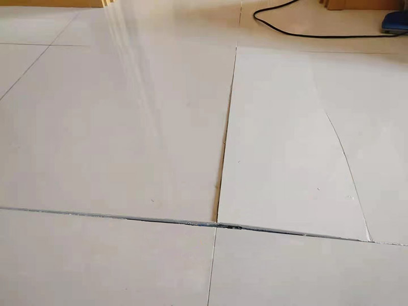 客廳地磚起翹修復(fù)：將油灰刀的邊緣滑入松散的瓷磚與其旁邊的瓷磚之間的接縫中。撬起瓷磚并將其移除。用金屬刮刀或小的撬桿的平坦邊緣刮掉基材和瓷磚背面的稀釋劑或瓷磚粘合劑。用相同的工具刮擦周?chē)臻g的舊水泥漿。用清水沖洗除去翹起的瓷磚，然后用濕海綿擦拭，使其干凈。將砂漿抹在缺口邊緣上，然后將稀釋水泥砂漿抹在瓷磚的背面，將瓷磚鋪回原位。如果難以將瓷磚平整，則將瓷磚墊片插入接縫或修補(bǔ)物與包圍它的瓷磚之間的接縫或接縫中。刮掉多余的漿液，并讓該區(qū)域靜置約10分鐘。用水蘸軟海綿，然后輕輕擦拭修復(fù)區(qū)域。瓷磚上出現(xiàn)一層干粉后，請(qǐng)用干抹布擦拭。