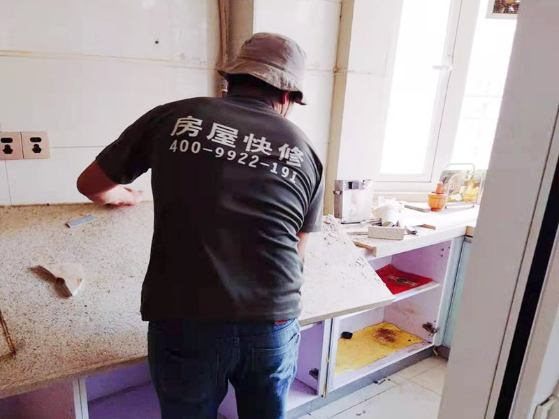 廚房櫥柜安裝：清理：對(duì)廚房作防護(hù)措施，掛擋布、廚房墻面等做簡單清理，以便準(zhǔn)確測量地面水平。櫥柜安裝一般先從地柜開始。把櫥柜外包裝拆開后。在櫥柜的邊緣貼上防火膜封邊。在下柜底部安裝上支腳，根據(jù)地面水平高度調(diào)整櫥柜。 櫥柜安裝需要找出基準(zhǔn)點(diǎn)，L型廚房從直角處向兩邊延伸，U型廚房則先將中間的一字型柜體放整齊后，再從兩個(gè)直角處向兩邊站看，這樣可以避免出現(xiàn)縫隙。櫥柜框架安裝牢固定位后，需要在櫥柜背面安裝背板。一般安裝下水都會(huì)現(xiàn)場開孔，工人會(huì)用專業(yè)的打孔器按照管道大小進(jìn)行打孔，打孔的直徑應(yīng)比管道大3-4毫米，并且打孔后要將開孔部分用密封條封邊，防止邊緣滲水木材變形。