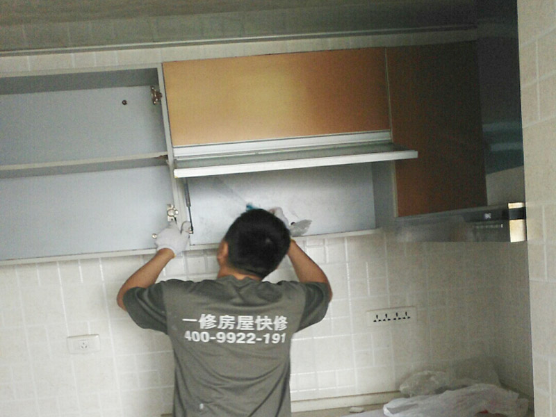   在安裝廚房吊柜之前，師傅要先用量尺確定了吊柜安裝的位置，確定好吊柜預(yù)定的位置，然后在墻面上鉆孔，便于塞入膨脹螺絲，安裝時(shí)先將拉桿裝入對(duì)應(yīng)安裝孔，然后將板塊連接，將吊柜提到吊片上，用工具扭緊螺絲釘固定。